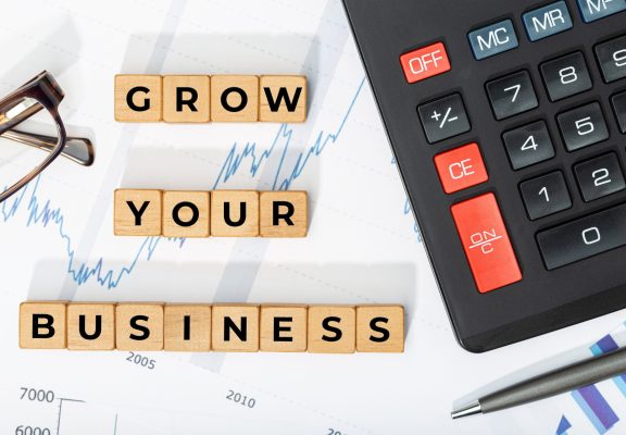 Grow your business concept. Wooden blocks with phrase, calculator and printed chars