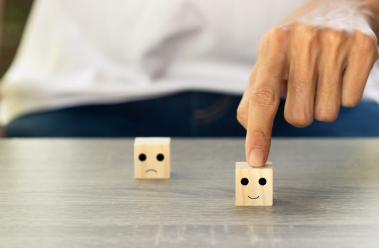 Conceptual the customer responded to the survey. The client using hand choose happy face smile icon on wood block. Depicts that customer is very satisfied. Service experience and satisfaction concept.