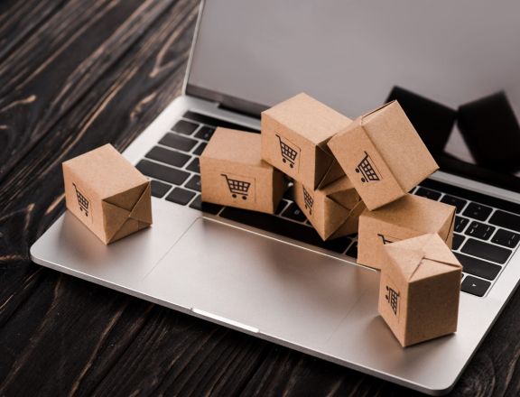 small carton boxes on laptop with blank screen, e-commerce concept